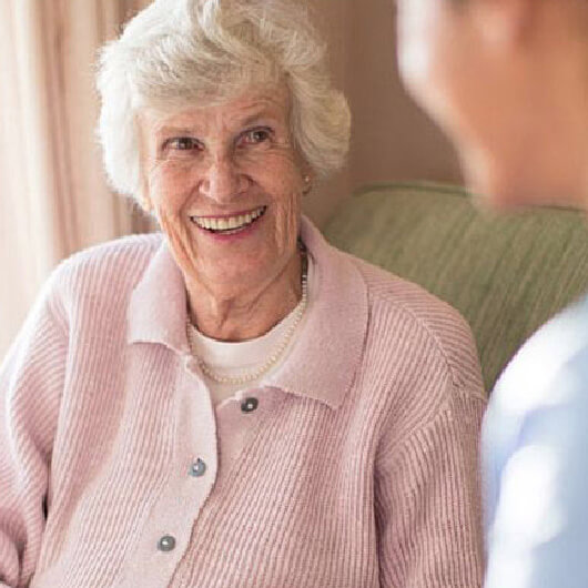 Elderly woman talking to in-home care worker